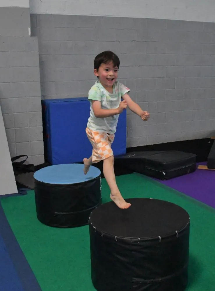 Preschooler hopping between soft blocks in Parkour Preschool at Bolt Parkour