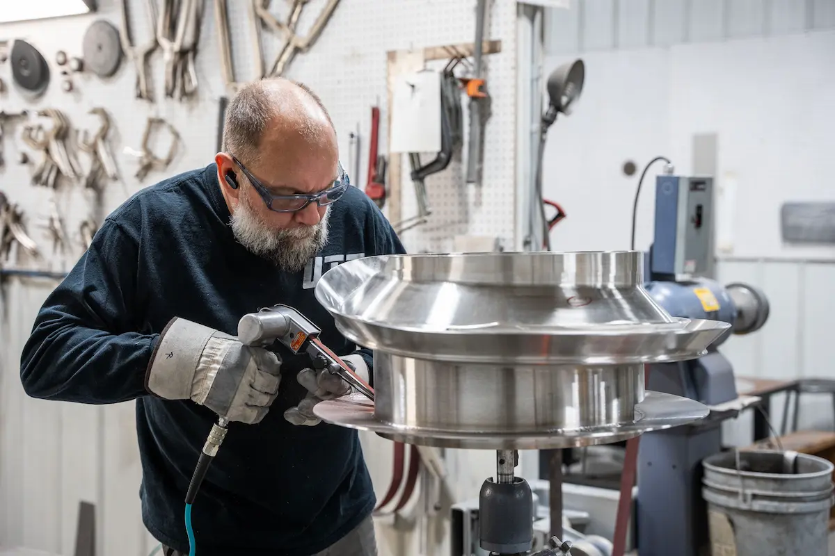 UTI technician finishing a feeder bowl in the shop