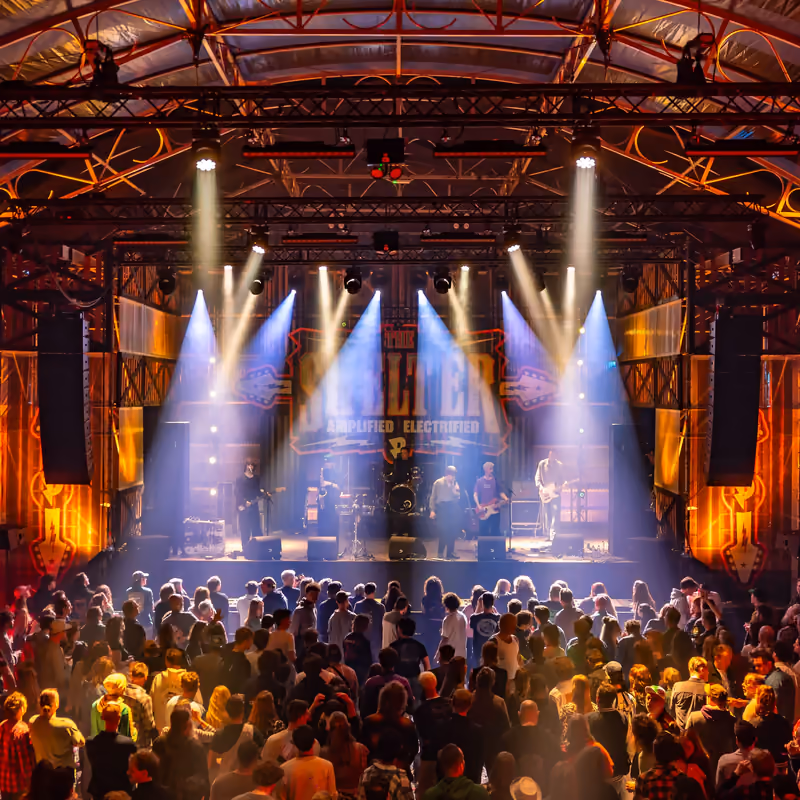 Een band in lichtbundels op het podium van The Shelter voor een volle zaal