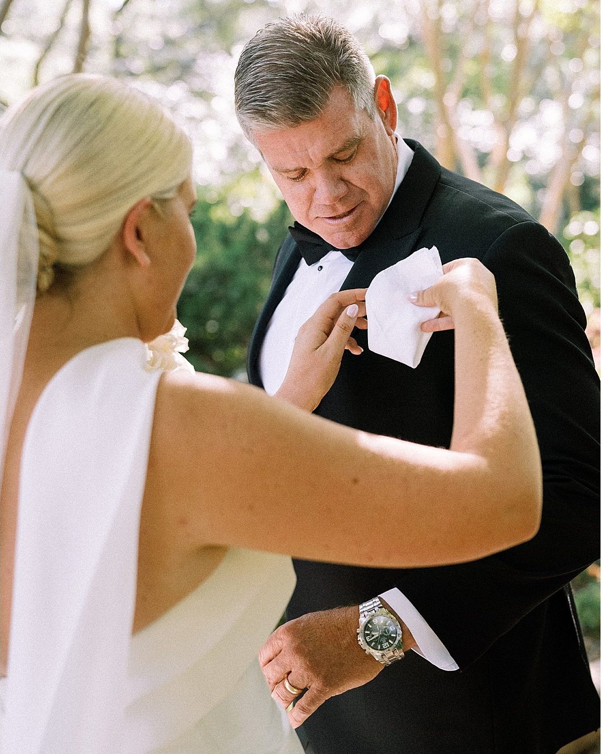The bride straightening the groom's pocket square before the ceremony