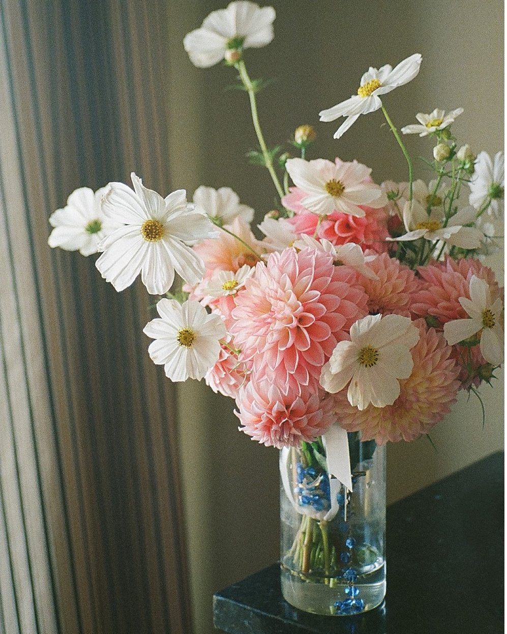Pink dahlias and white cosmos in a glass vase