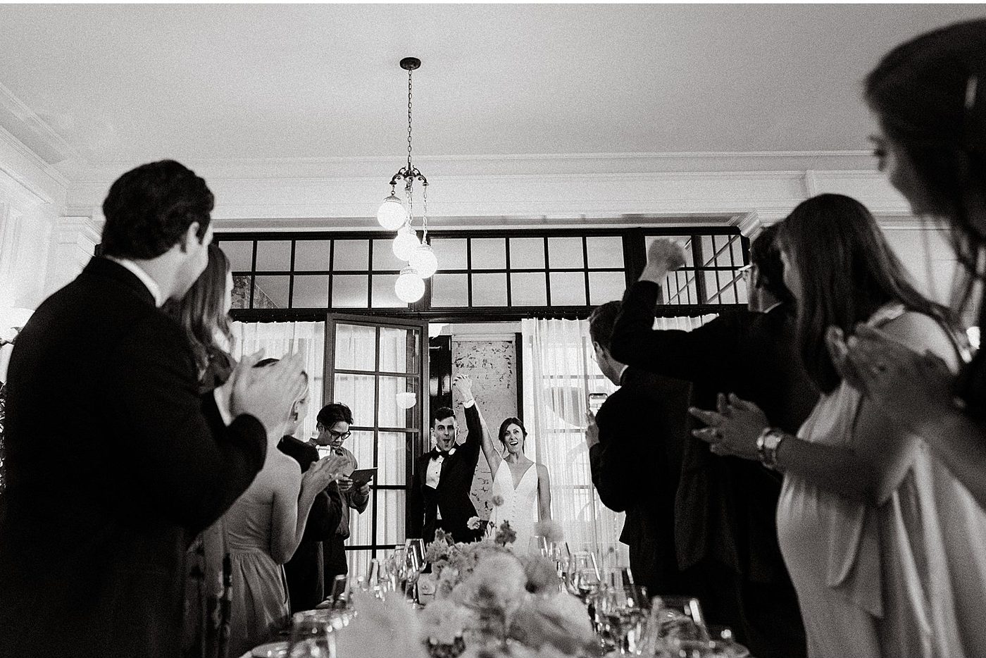 Black and white, guests gathered in a dining room