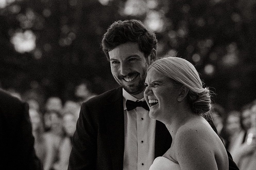 Black and white, a couple laughing under string lights
