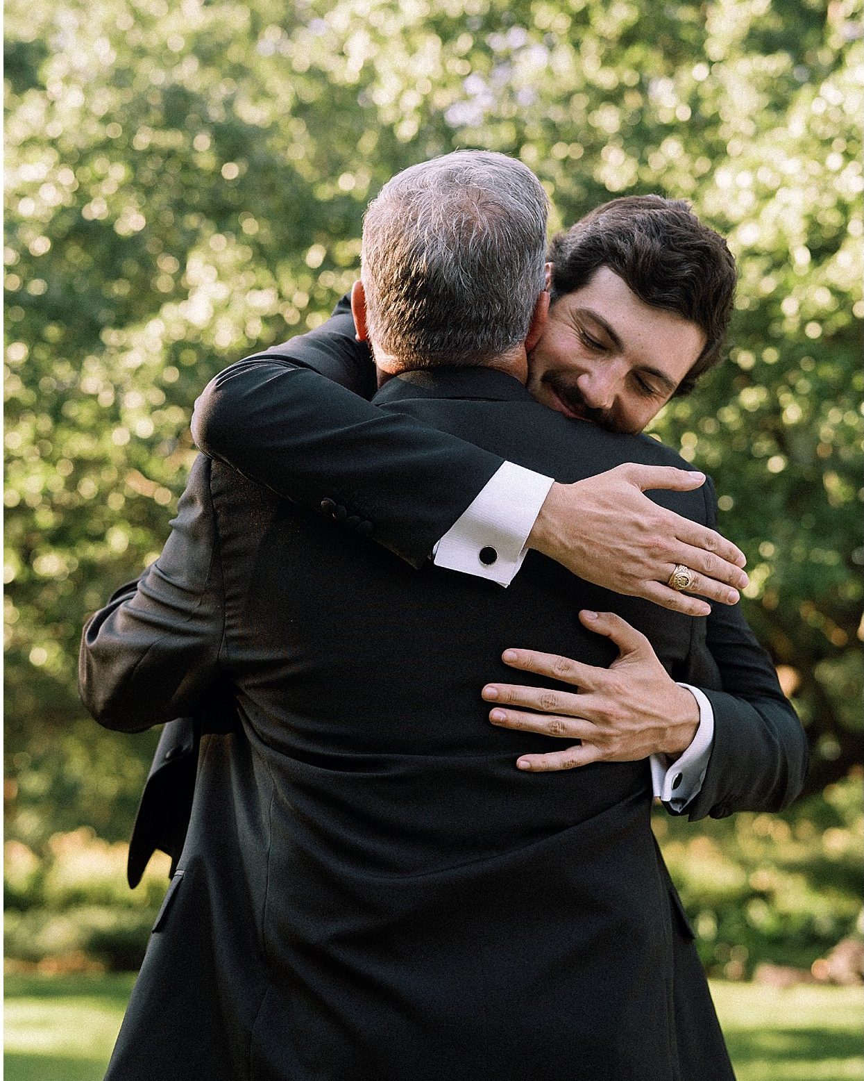 A groom hugging his father on the wedding day.
