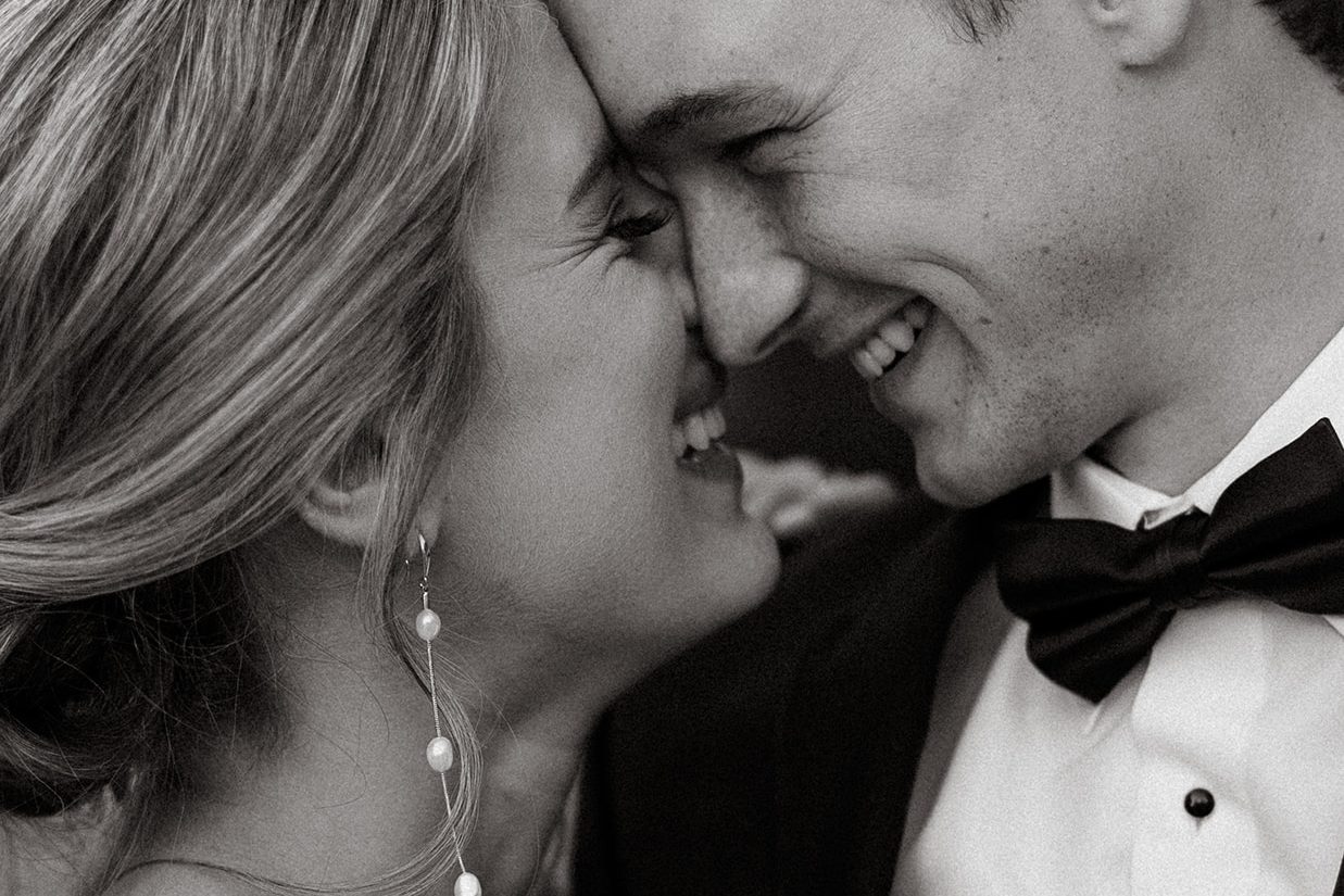 Black and white close portrait of the couple smiling forehead to forehead