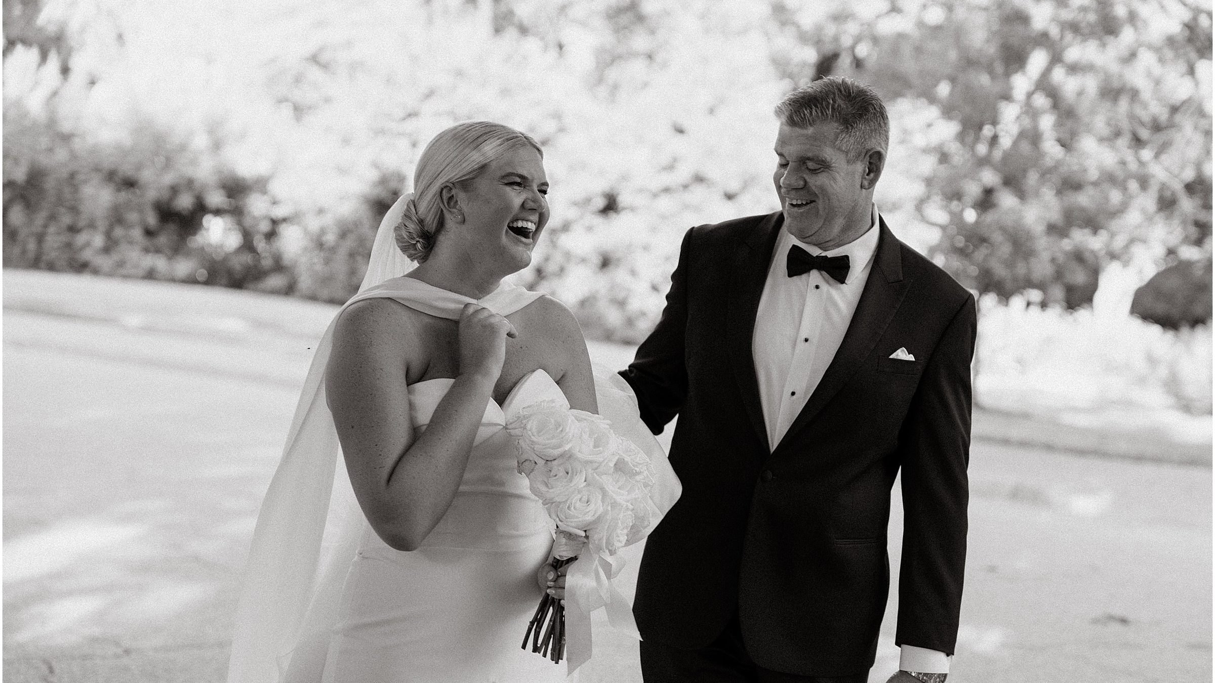 Black and white: a couple laughing as they walk through the Botanic Garden.