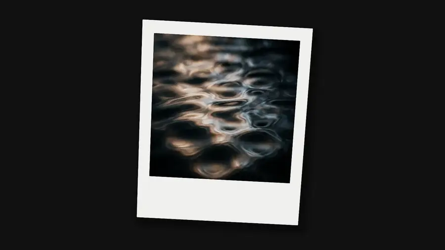 A Polaroid holding a picture of water caustics, its caption, summer '24, writing itself on