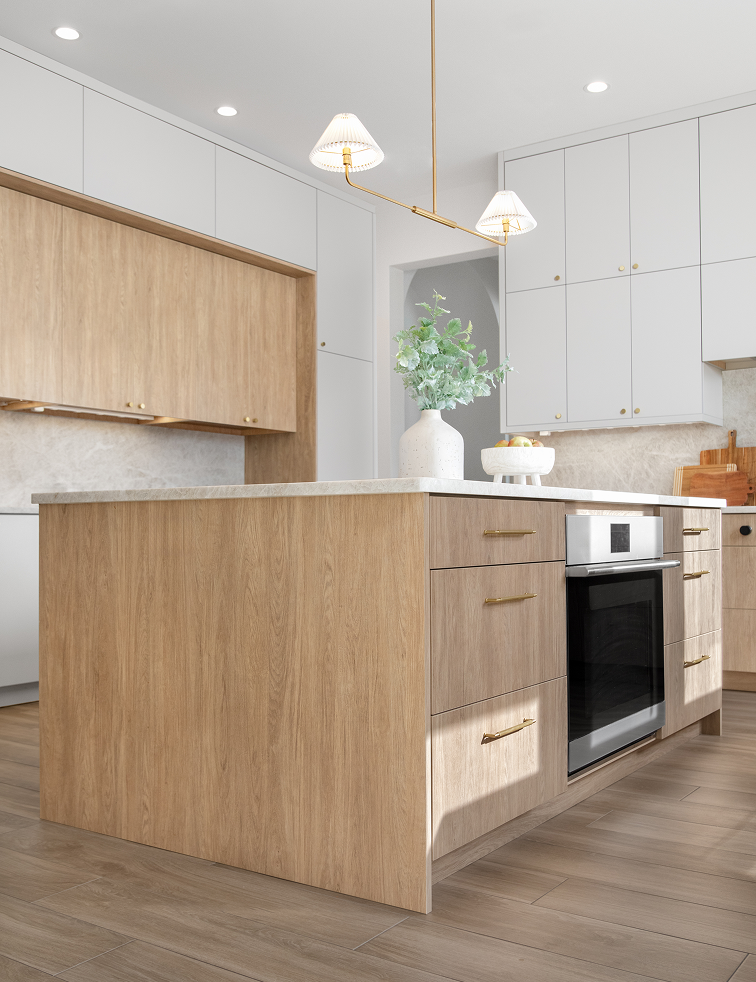 Modern kitchen with wood-finish island, white cabinets, built-in oven, and pendant lights.