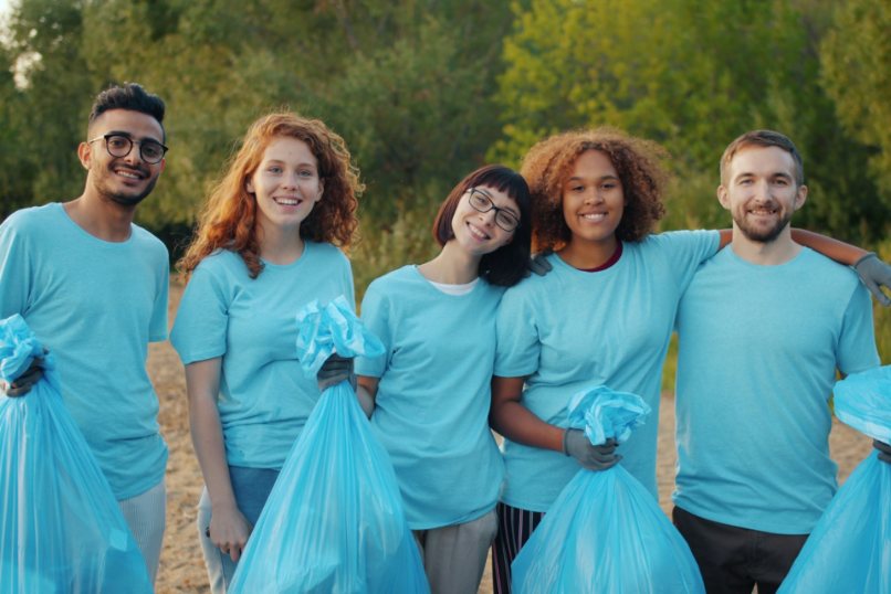 Young volunteers smiling after a community clean-up