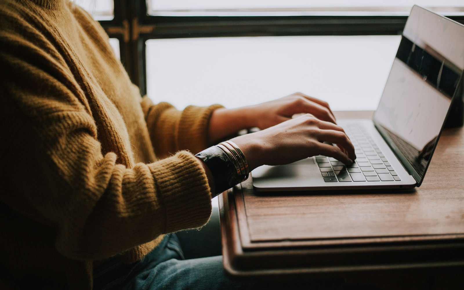 Person typing an email on a laptop at a desk