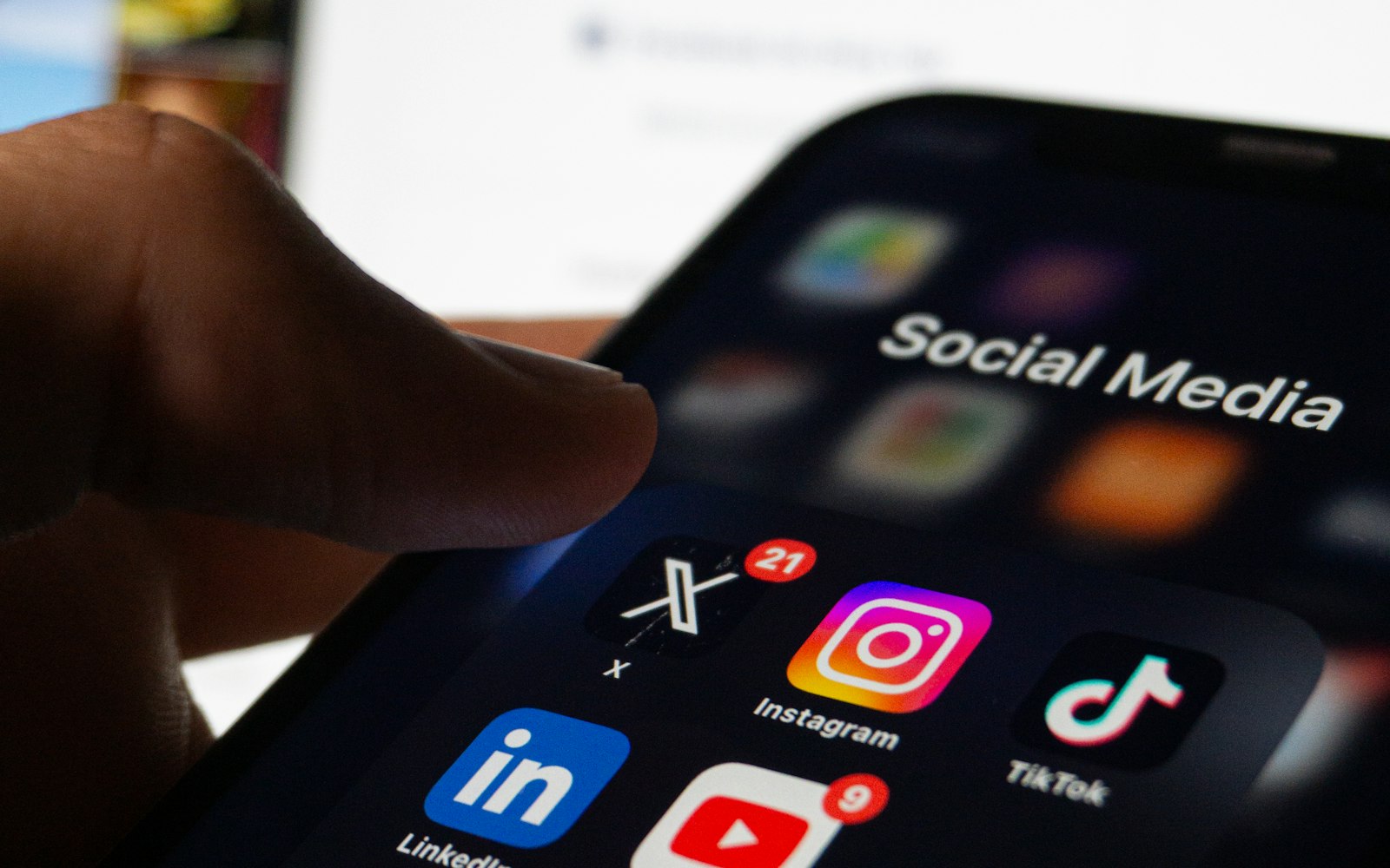 Person holding a phone with Instagram and other social media apps on the screen
