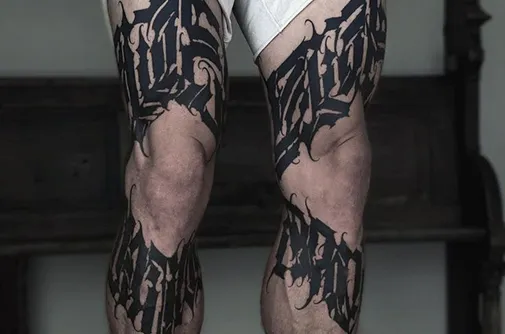 Blackwork lettering tattoo on both legs