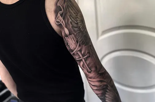 Cross and wings sleeve tattoo