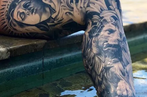 Leg sleeve tattoo with a Madonna portrait and a realistic lion in black and grey