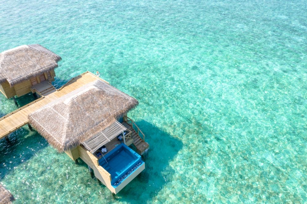 Thatched overwater villas above turquoise water
