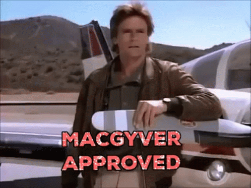 Animating gif of tv series character Angus "Mac" MacGyver. He's in front of an airplane folding his arms with the words "Macgyver approved" at the bottom of this gif.