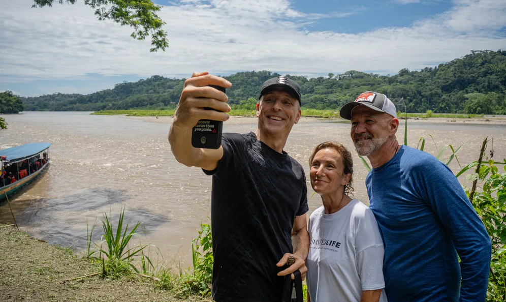 Guests taking a selfie on the banks of an Amazon river