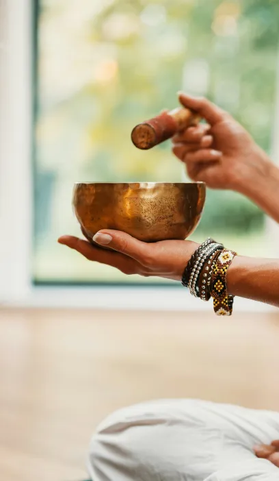 Hands playing a singing bowl