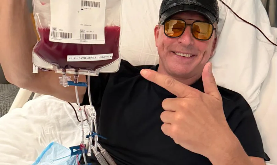 Smiling member pointing to his infusion during a therapy session