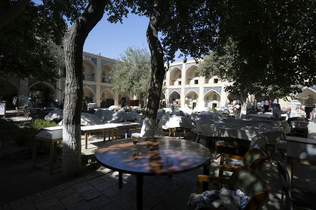 Shaded courtyard with arched alcoves in Bukhara