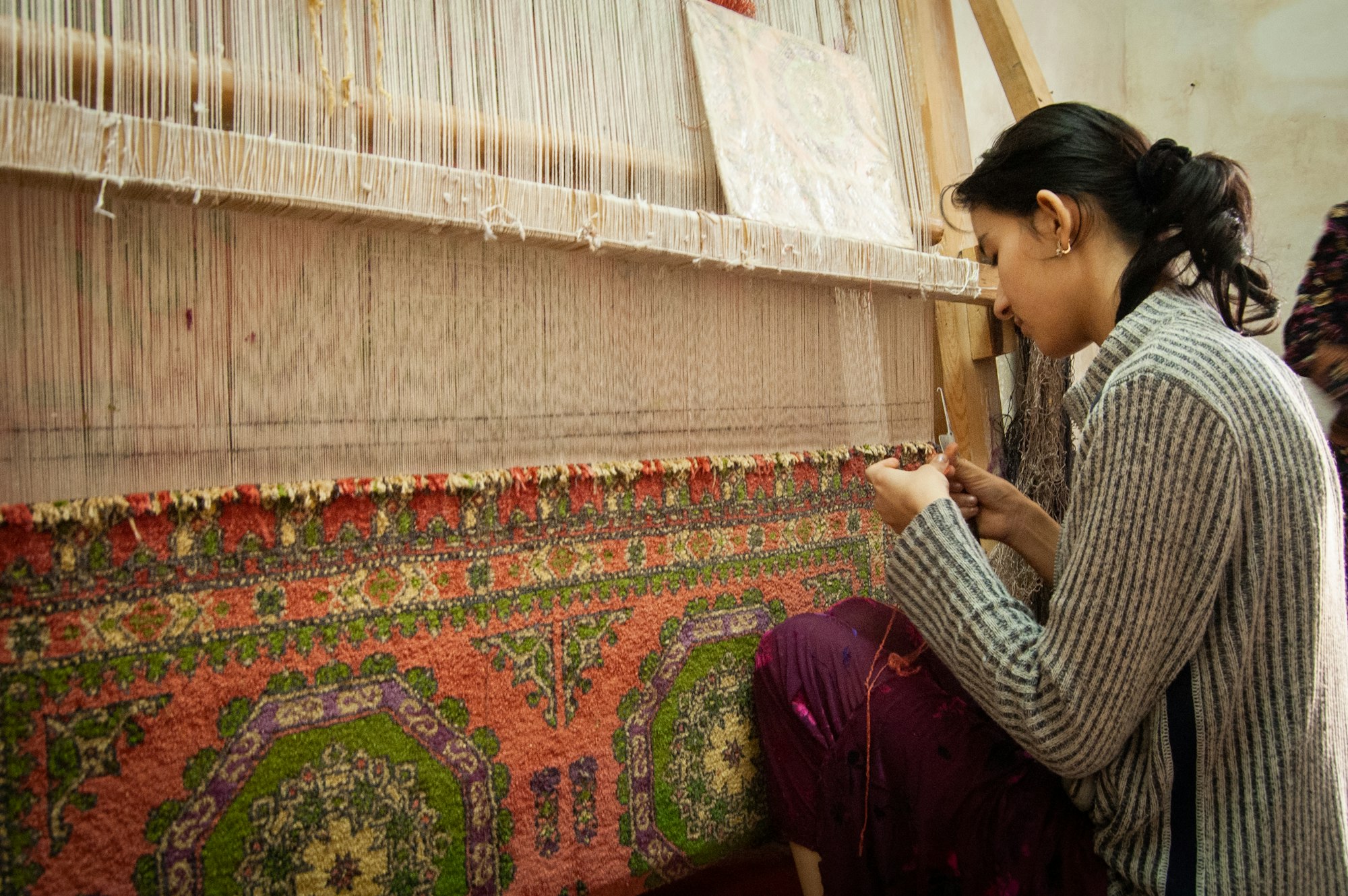 Carpet weaver at work on a loom