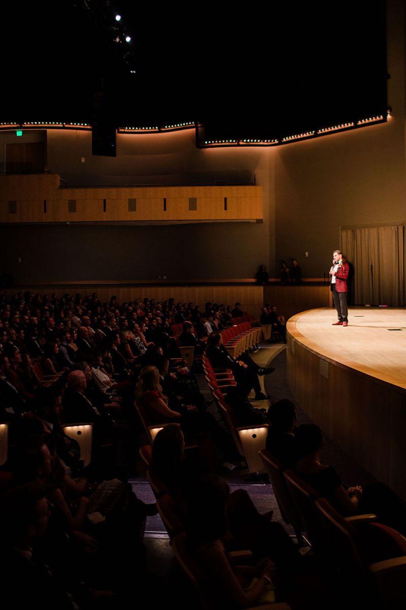 A speaker addresses the audience from the stage