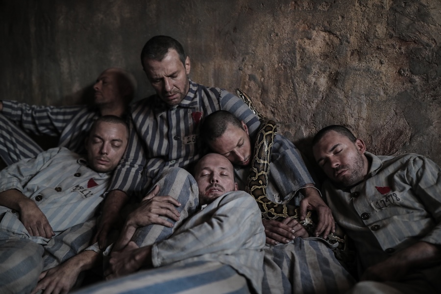 Prisoners huddle together in the cell, from Triumph of the Heart