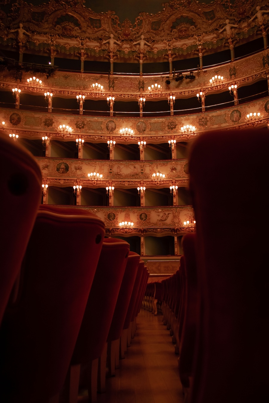 Rows of empty red velvet theater seats