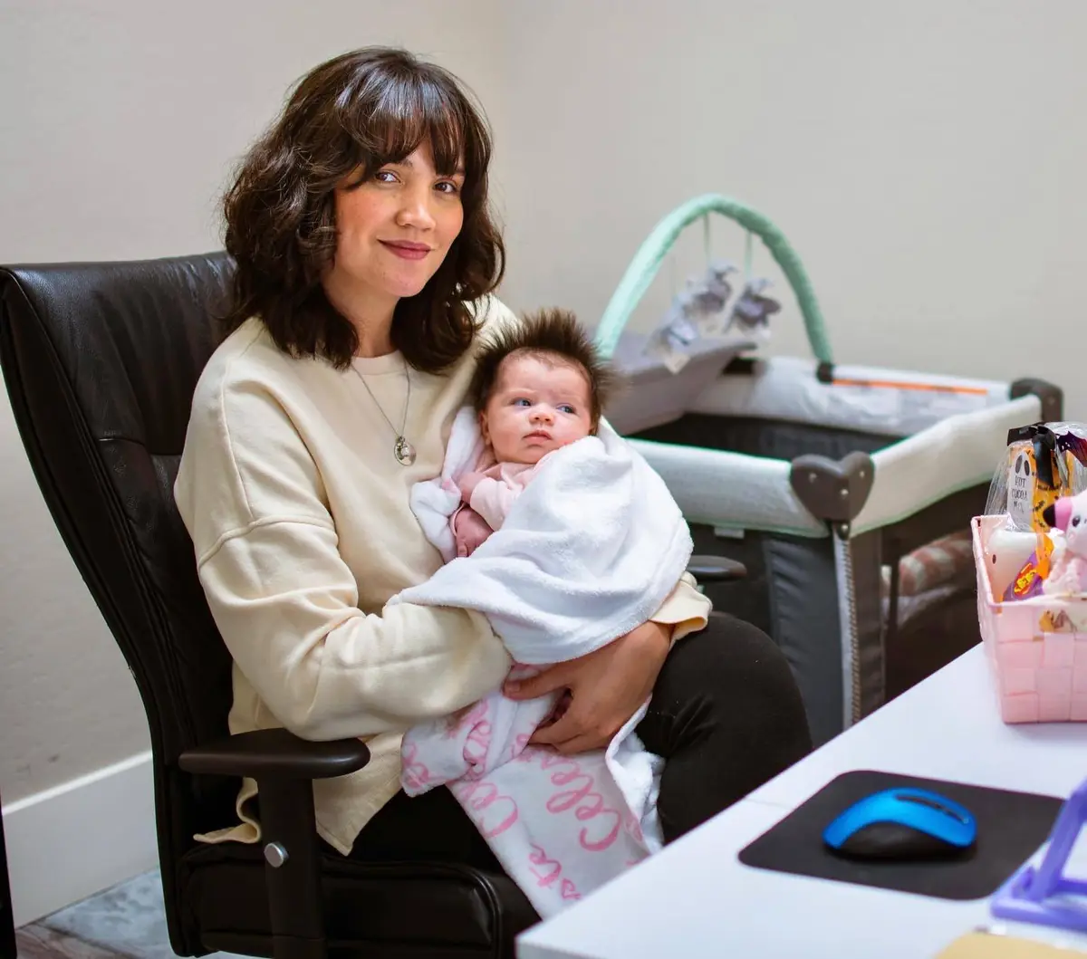 Social Media Coordinator, Photographer, and Videographer of Axis Roofing with baby in the Axis Office