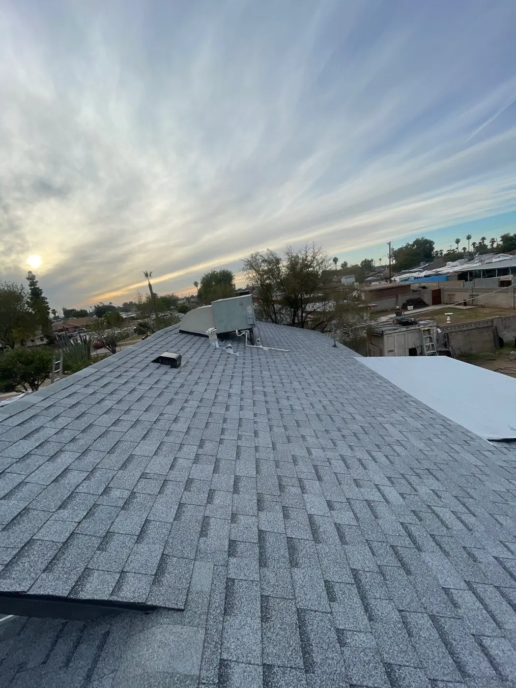 A photo of a finished roofing project done by Axis Roofing on a gray shingle roof in Mesa, Arizona