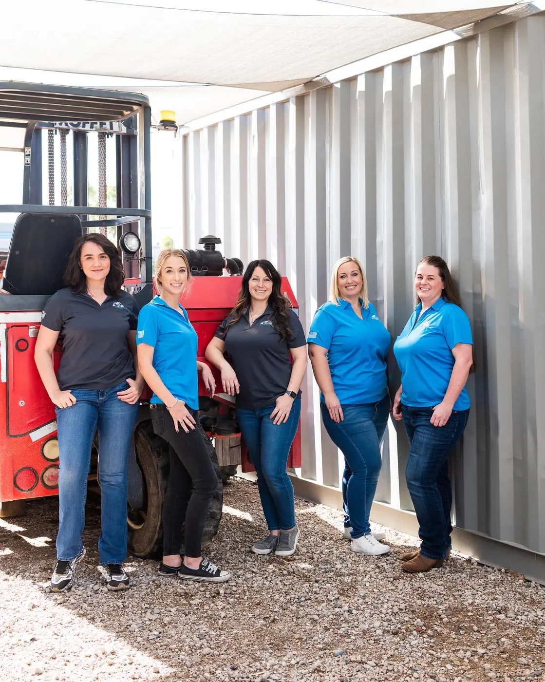 Women roofers of Axis Roofing celebrating women in construction while posing for a photo in front of the Axis Roofing office in Mesa, Arizona