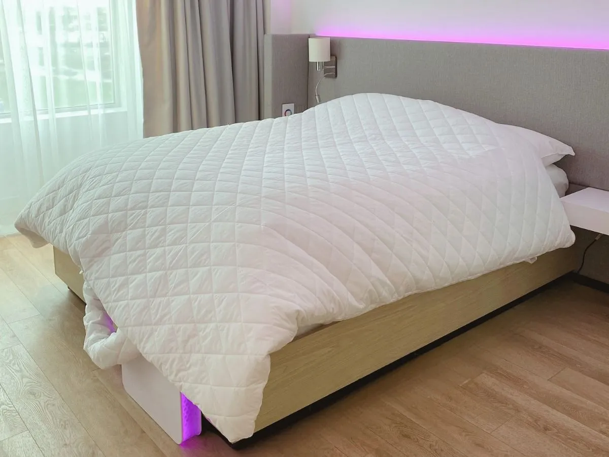 A bedroom lit by soft ambient light under the bed
