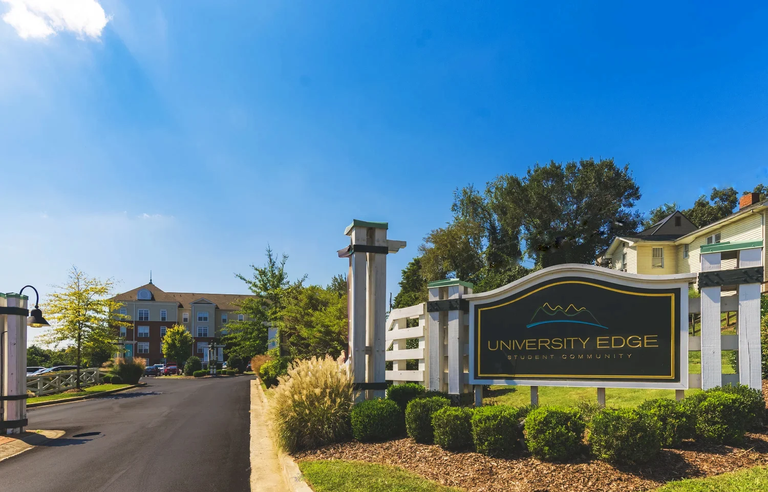 View of property sign with apartments in background