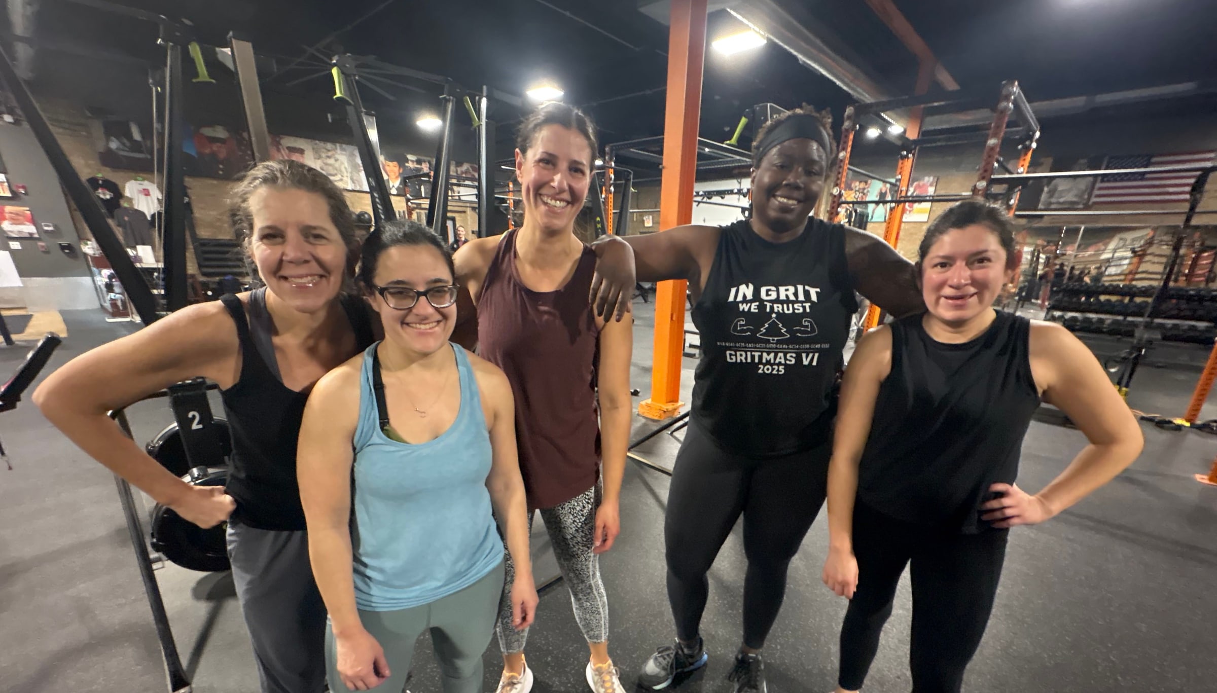 Five smiling members posing together inside Three Bears Fitness in Forest Park, IL