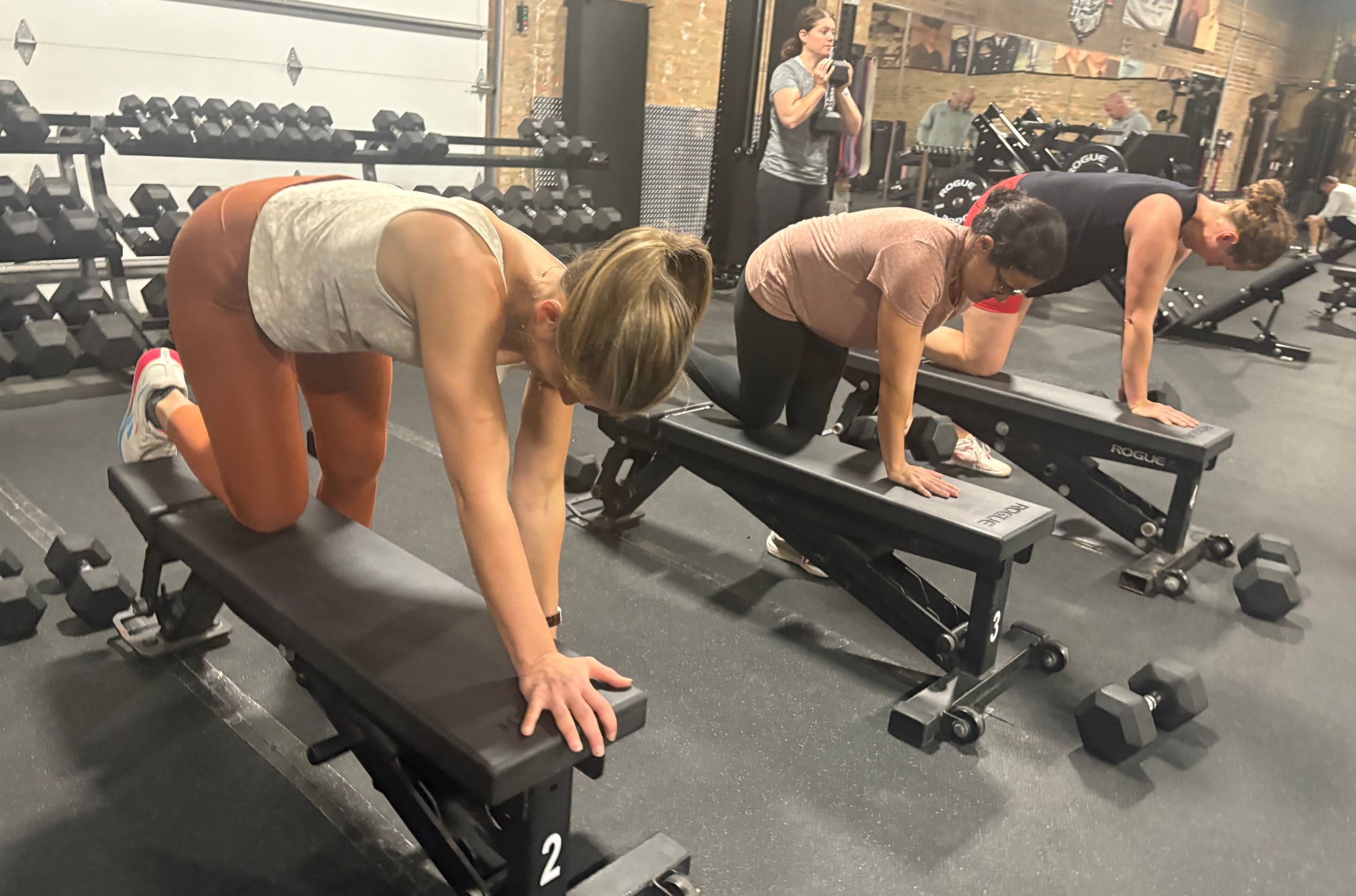 Members doing bench-supported dumbbell rows during a class at Three Bears Fitness in Forest Park, IL