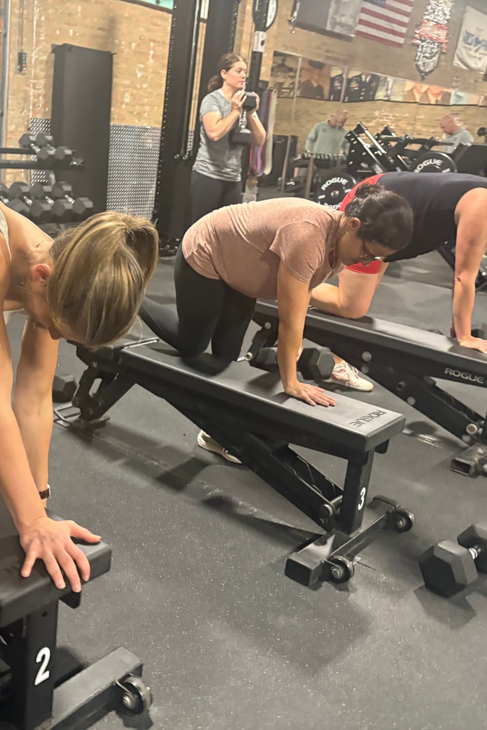 Members doing bench-supported dumbbell rows during a class at Three Bears Fitness in Forest Park, IL