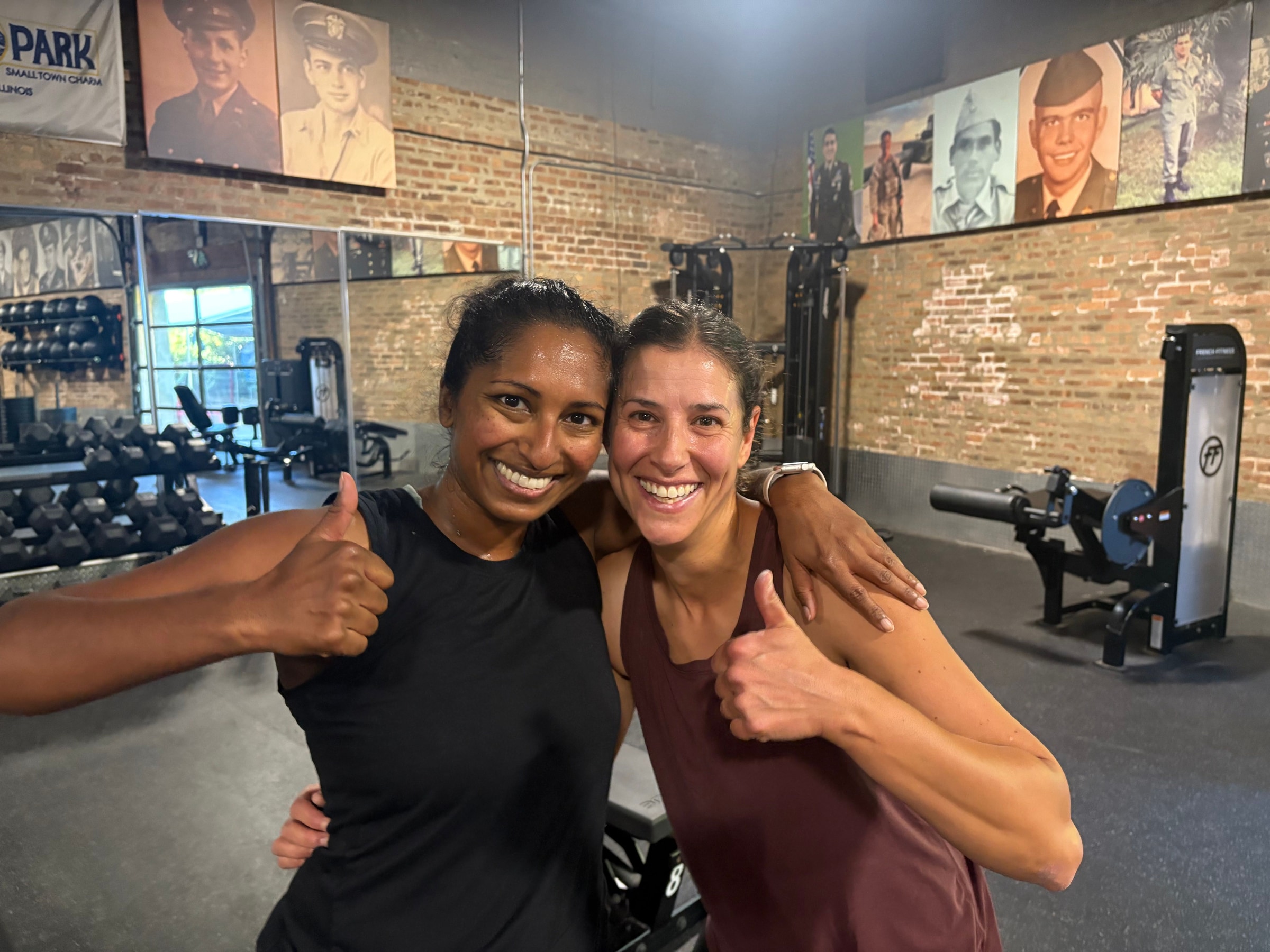 Two smiling members giving thumbs up with arms around each other at Three Bears Fitness in Forest Park, IL