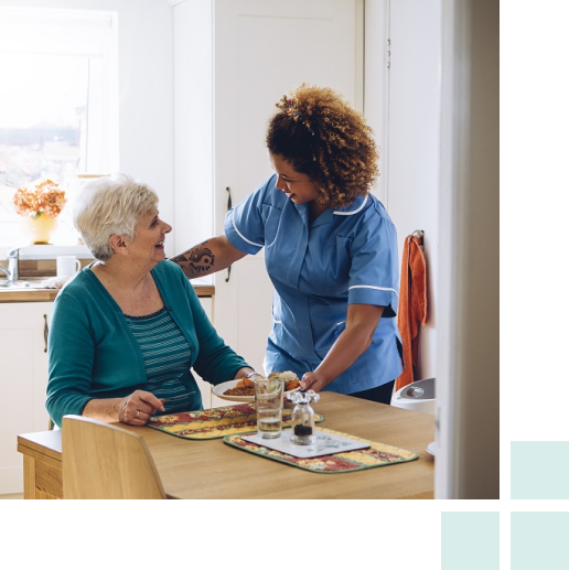 A woman and an older woman collaborate in a bright kitchen, sharing a moment of joy while preparing a meal together.