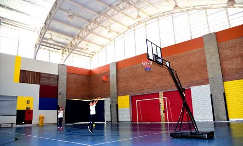 Ginásio coberto com quadra e tabela de basquete
