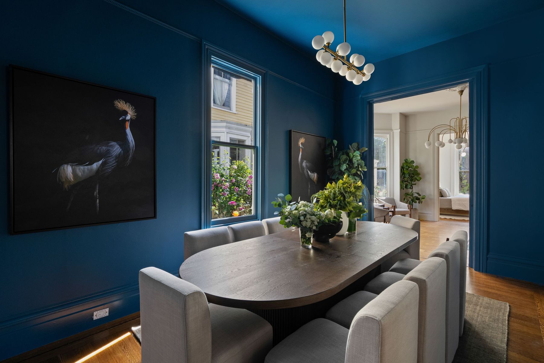 A Victorian dining room painted deep blue under a glass chandelier, San Francisco. Editorial interior photography by Lumiful Media