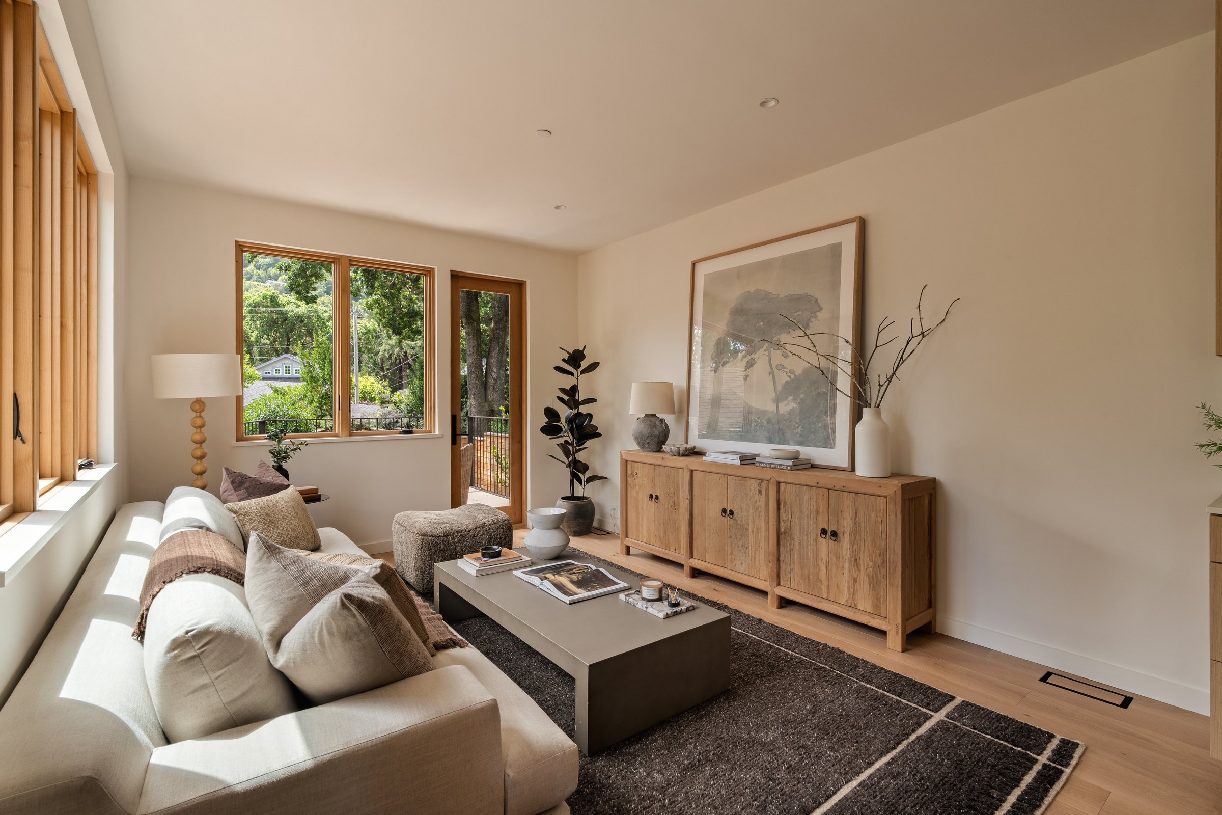 A bright living room with a linen sofa, an oak cabinet and garden windows, Fairfax. Real estate photography by Lumiful Media