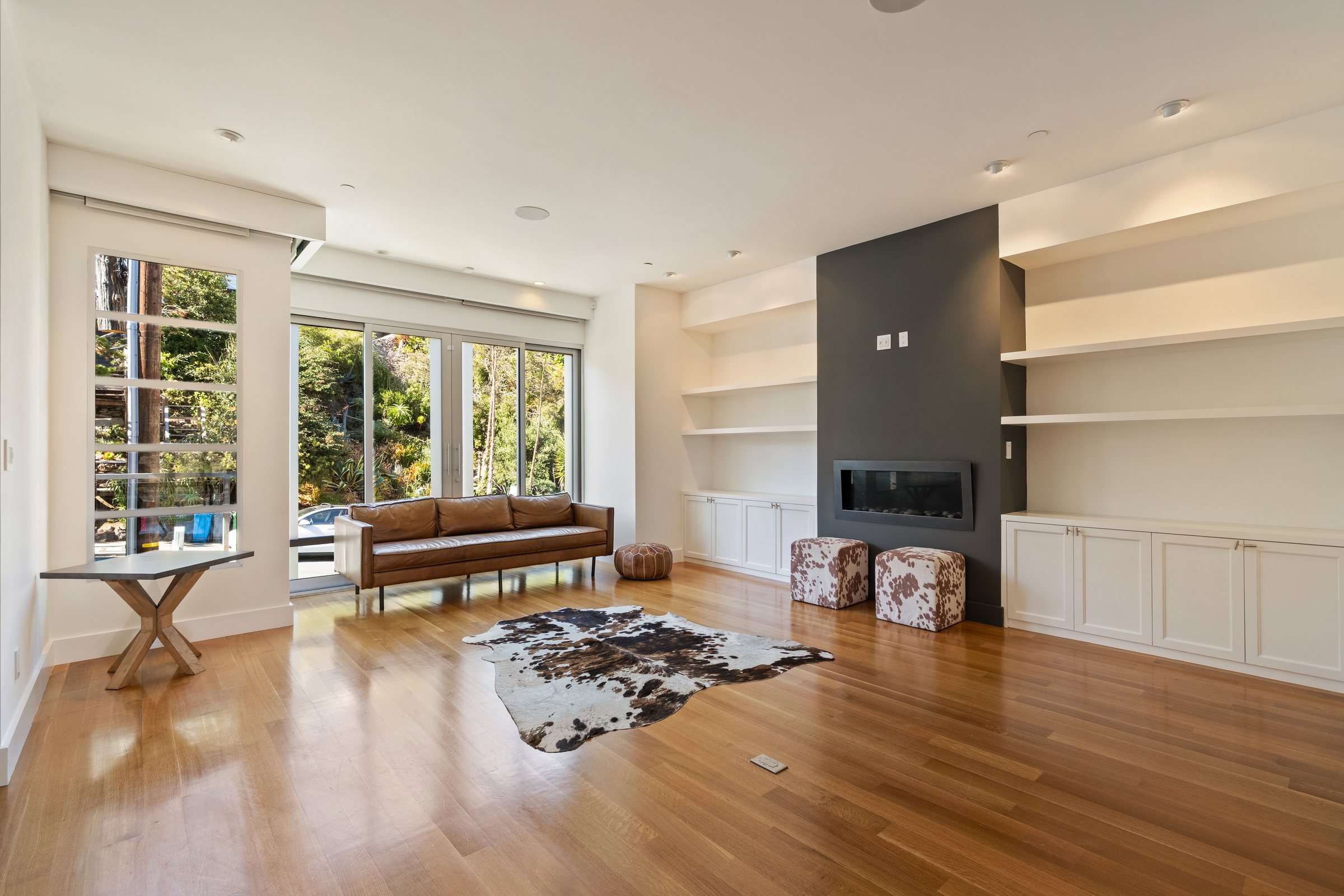An empty living room with a fireplace before virtual staging, San Francisco. Virtual staging by Lumiful Media