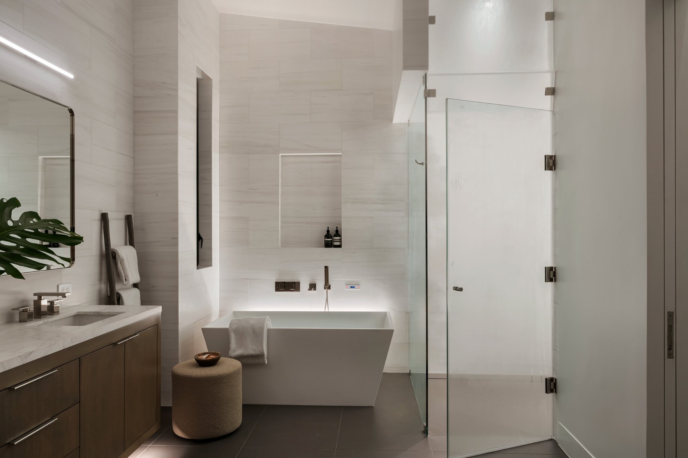 A freestanding tub in a pale stone bath, San Francisco Bay Area. Real estate photography by Lumiful Media