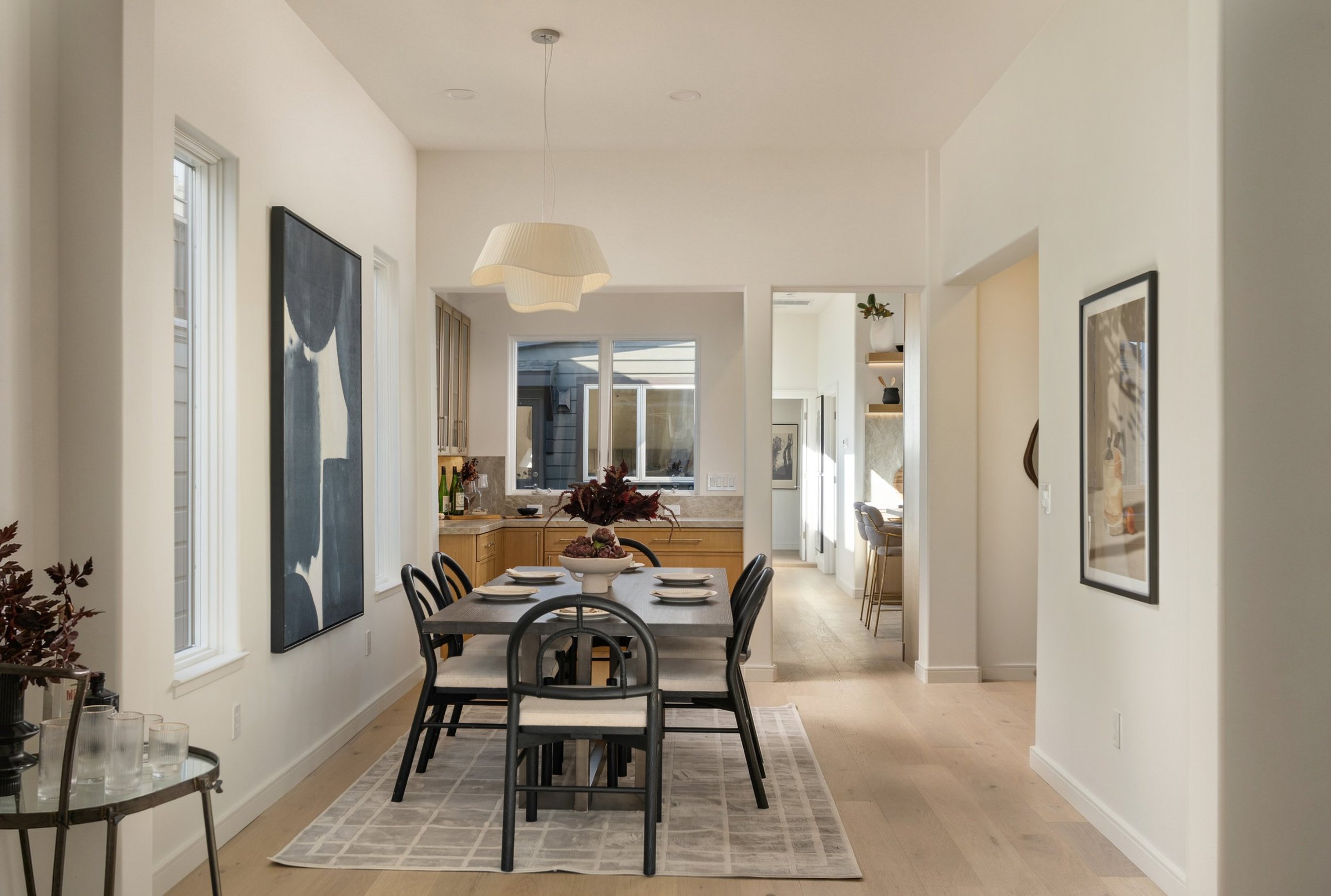 A dining room with black chairs and a pleated pendant, San Francisco Bay Area. Real estate photography by Lumiful Media