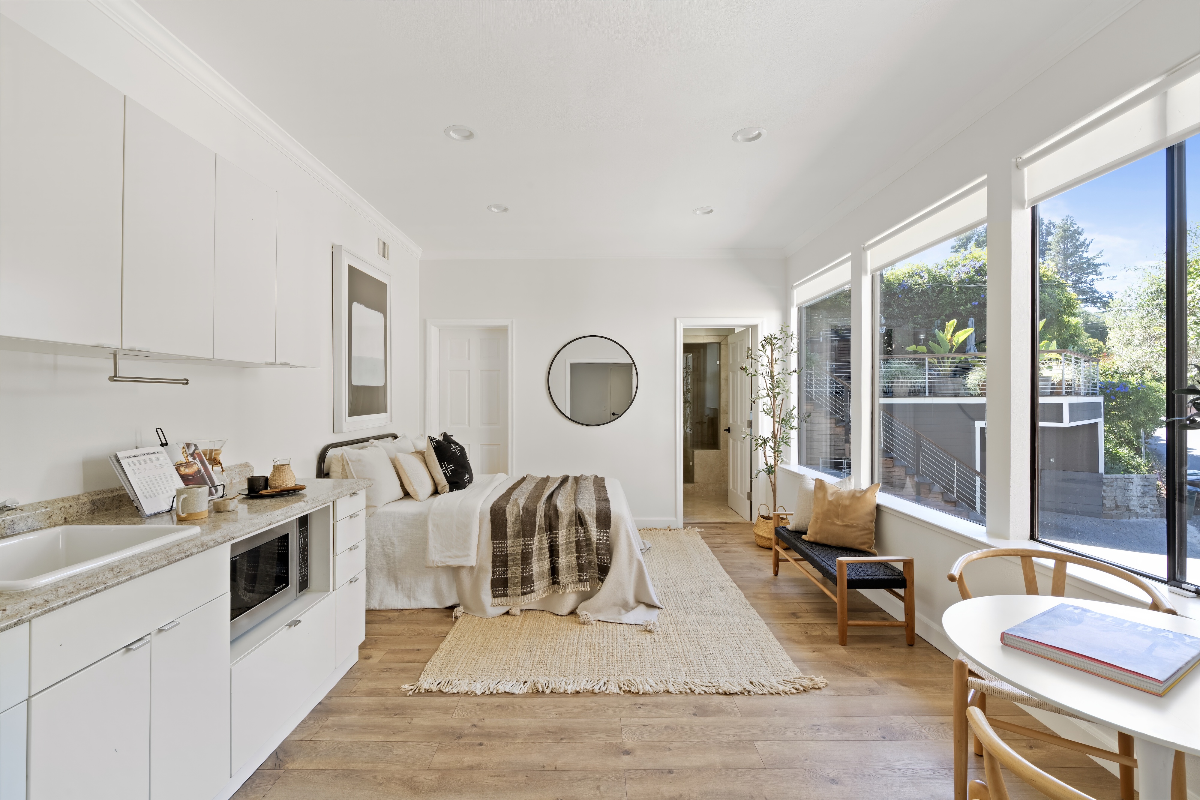 A bright studio with a kitchenette and a wall of windows, San Francisco Bay Area. Real estate photography by Lumiful Media