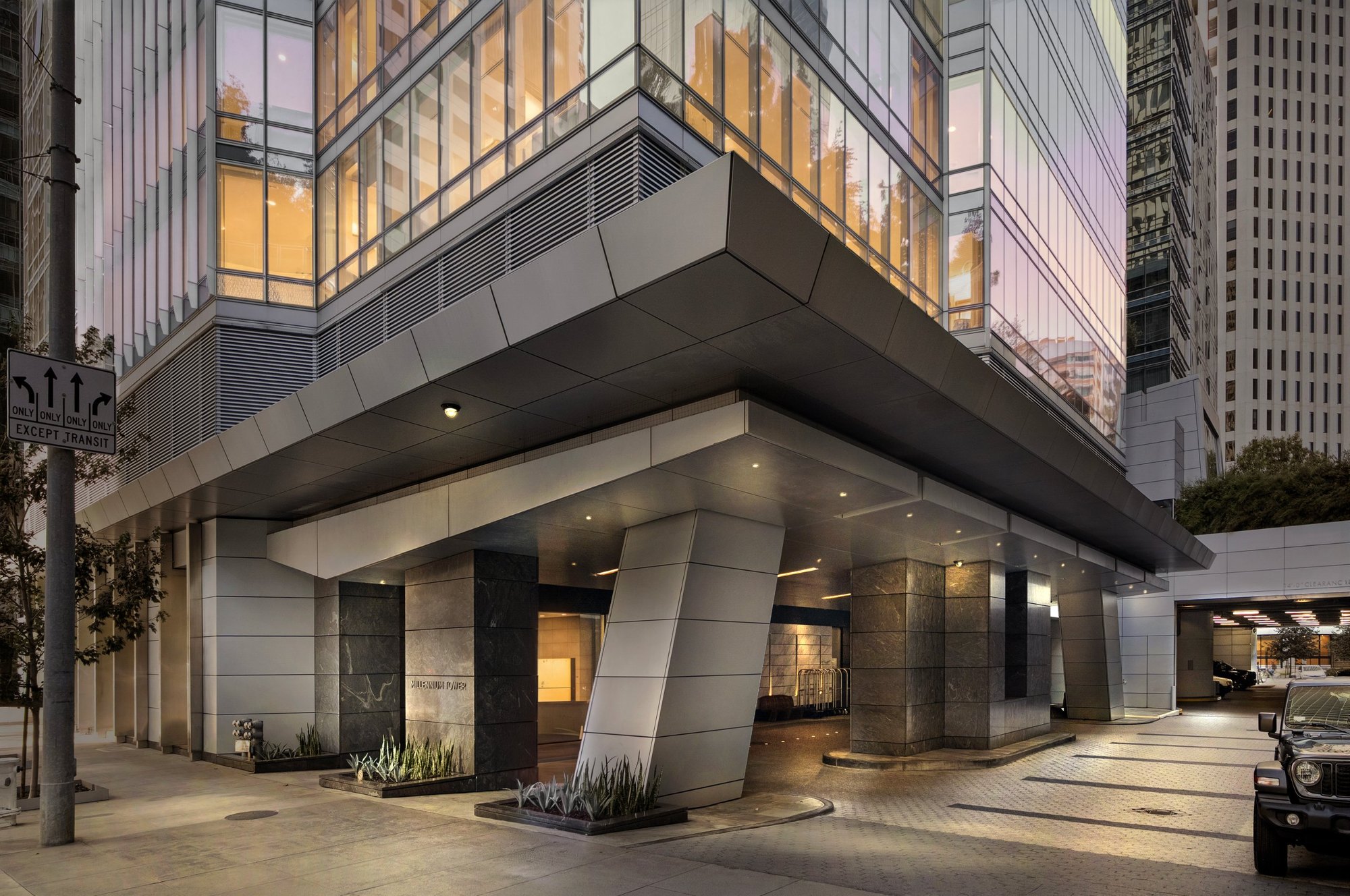 The same high rise entry shown as a virtual twilight, with warm lit windows, San Francisco. Virtual twilight by Lumiful Media