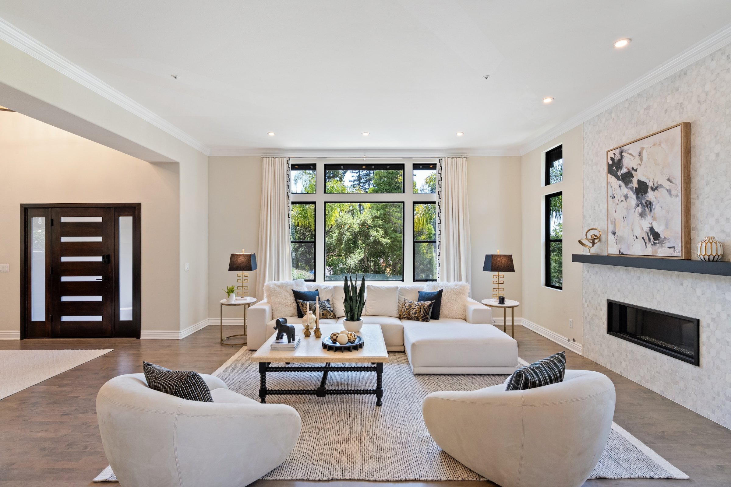A bright living room with a linear fireplace and curved white chairs, Marin County. Real estate photography by Lumiful Media