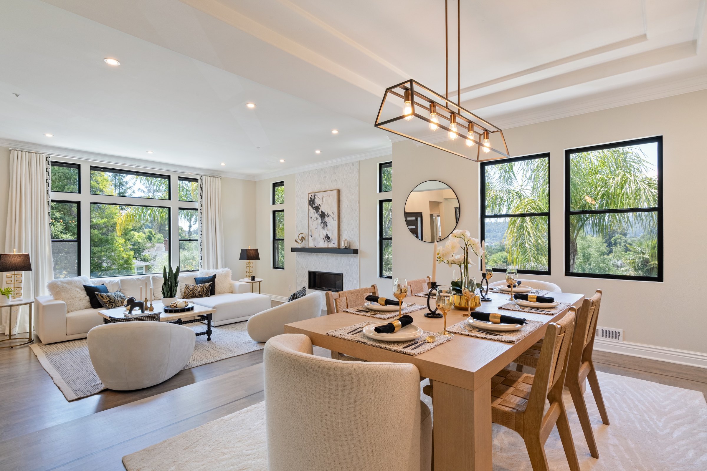 An open dining room with a long oak table and an iron chandelier, Marin County. Real estate photography by Lumiful Media
