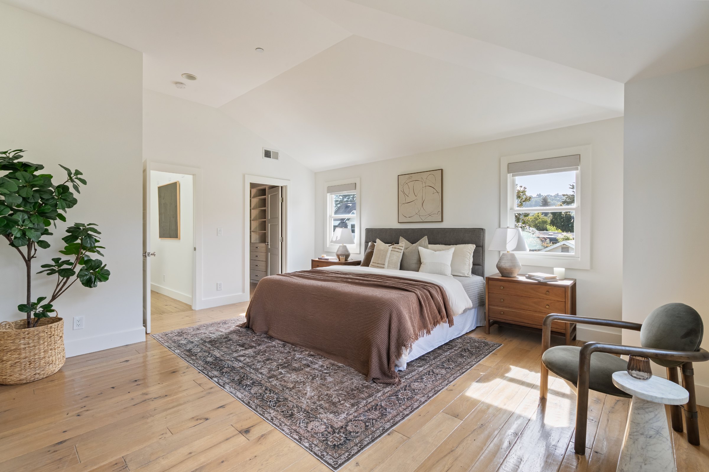 A primary bedroom with a vaulted ceiling and a patterned rug, Marin County. Real estate photography by Lumiful Media