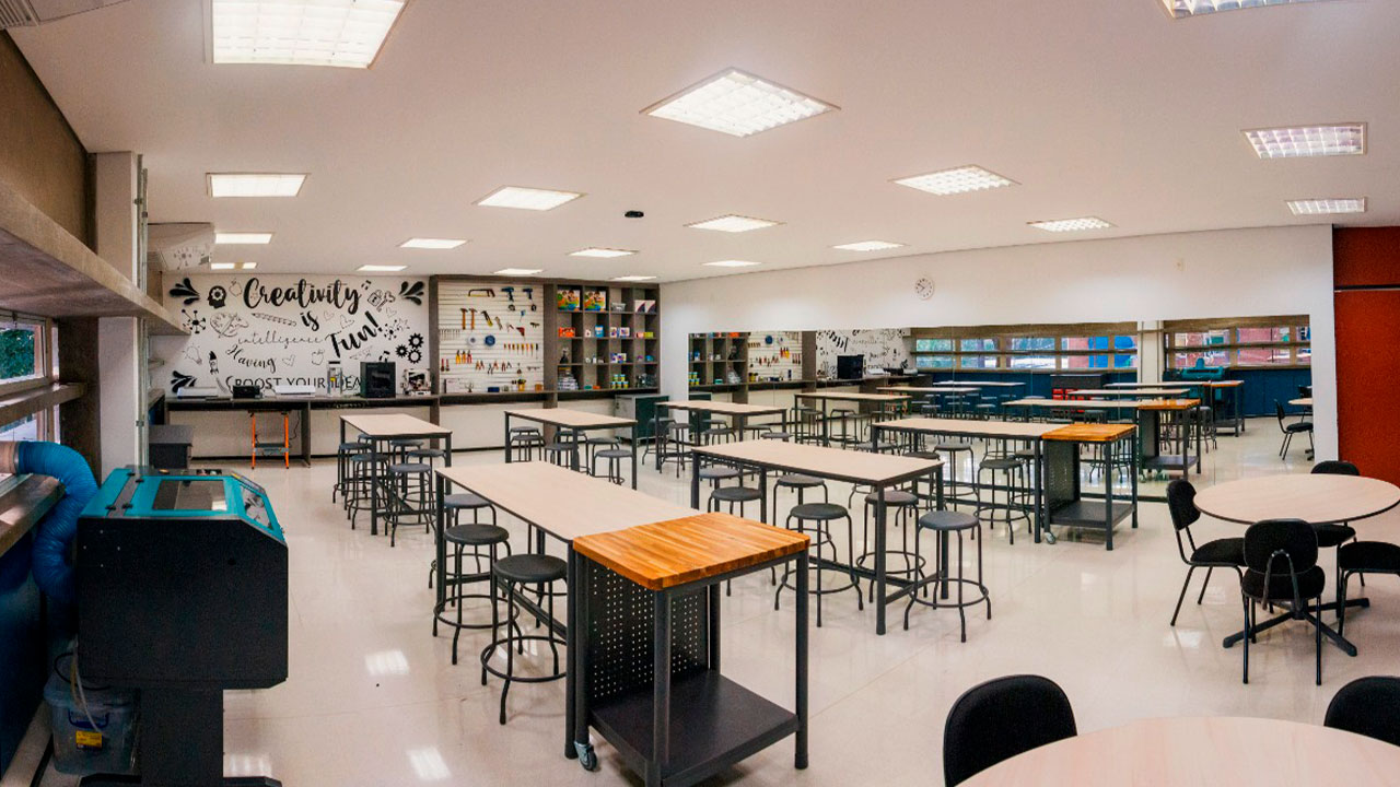 Espaço maker vazio com bancadas, ferramentas e materiais para atividades